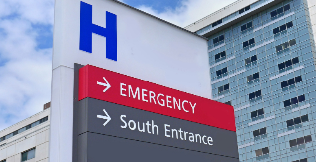 A tall hospital sign with a large blue letter 